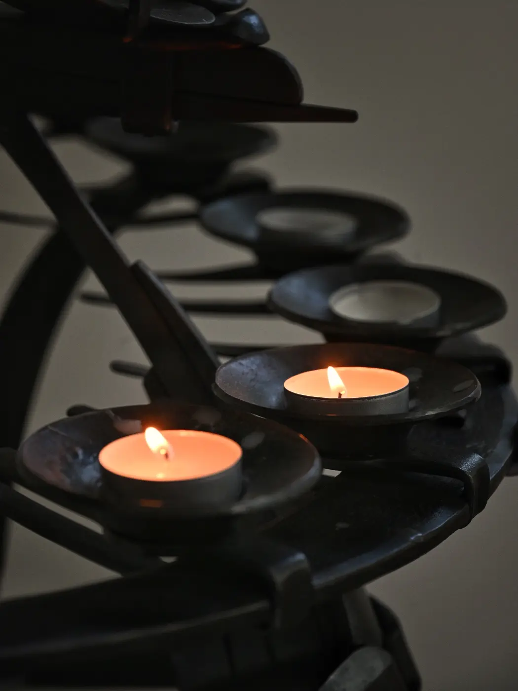 Several candles burning in dark sculpted holders