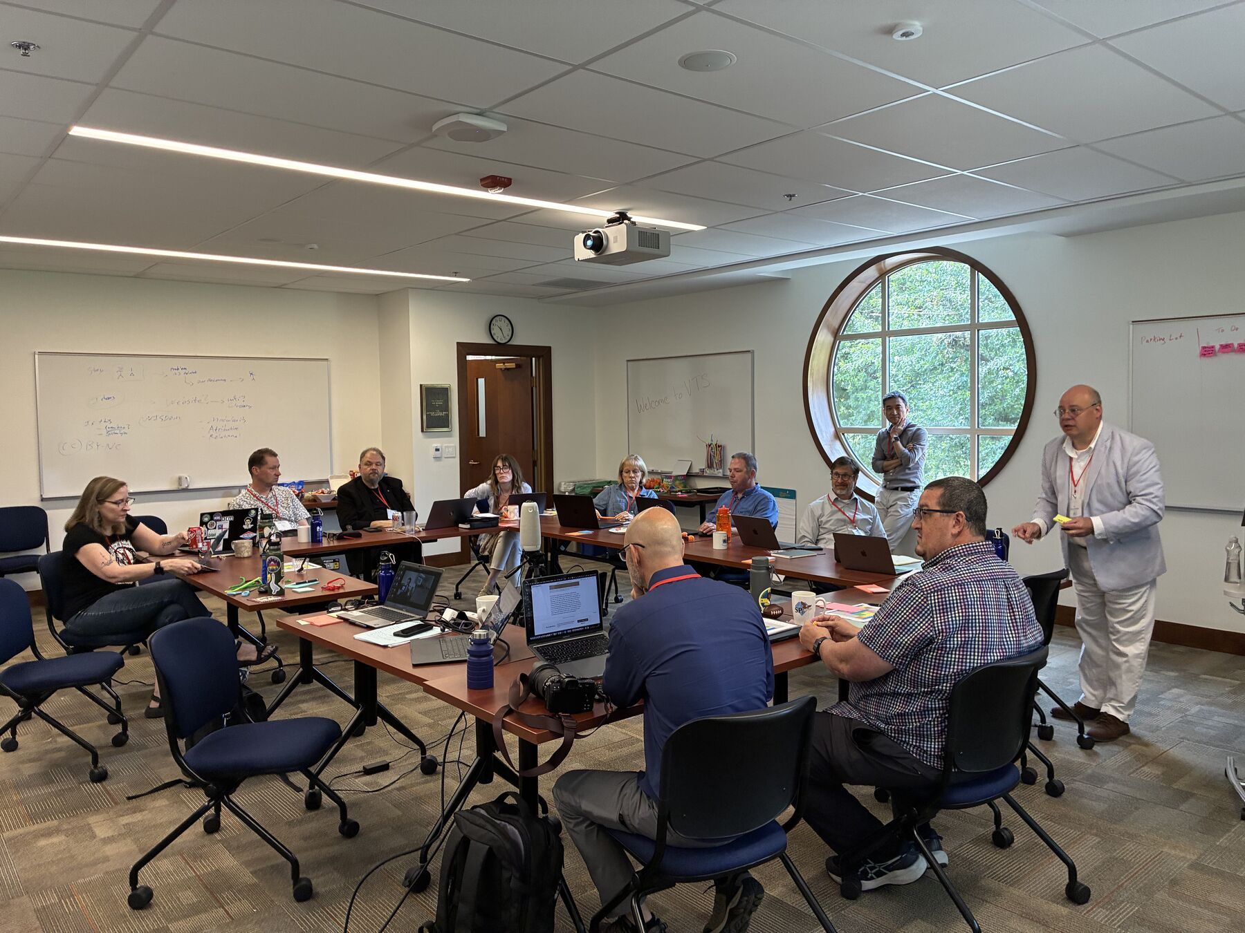 An ecumenical team of clergy and practitioners working together around tables at the toolkit design sprint