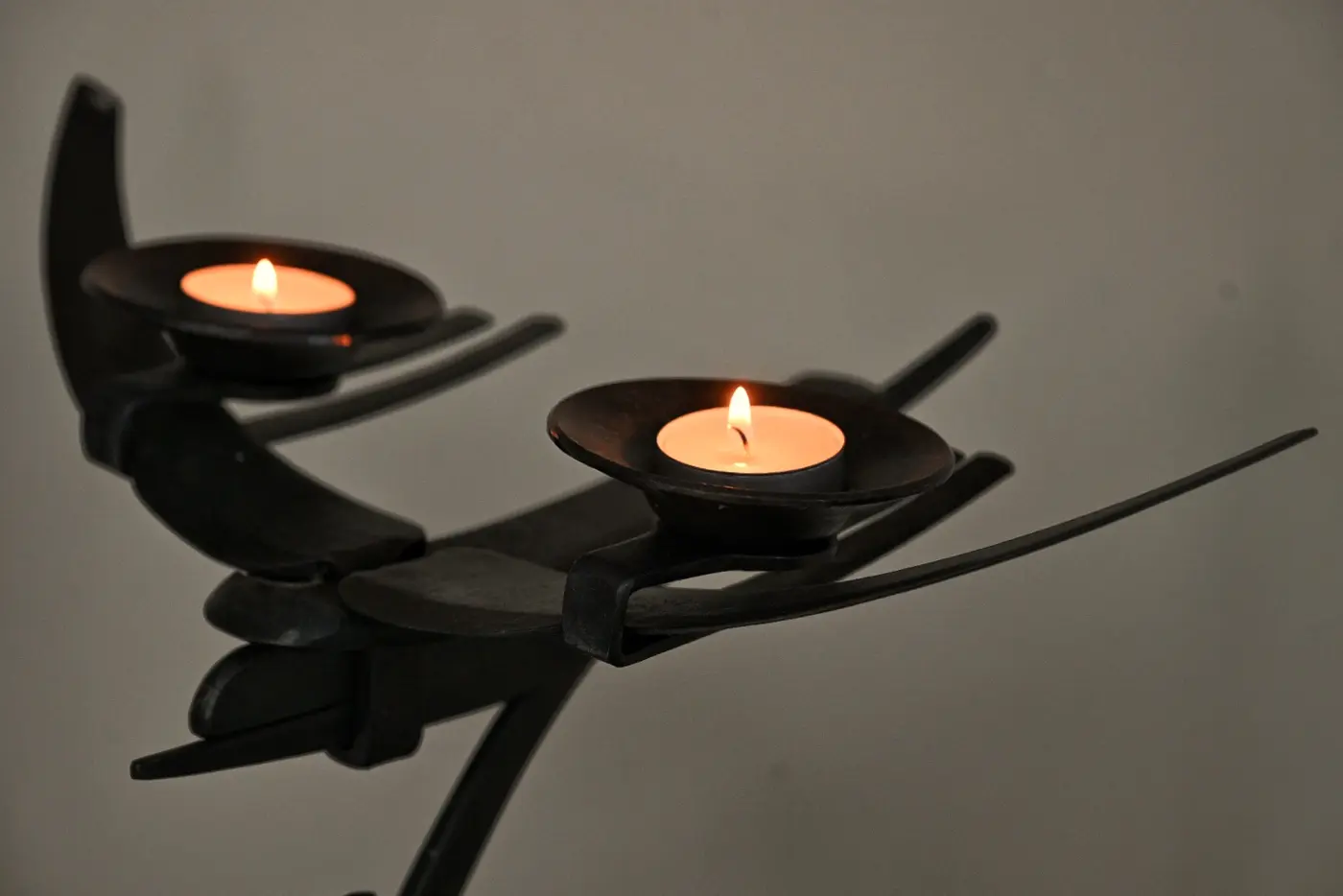Two lit candles held in sculpted hands